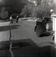 Men filling cracks in the road along the scenic canyon drive near the Grotto.