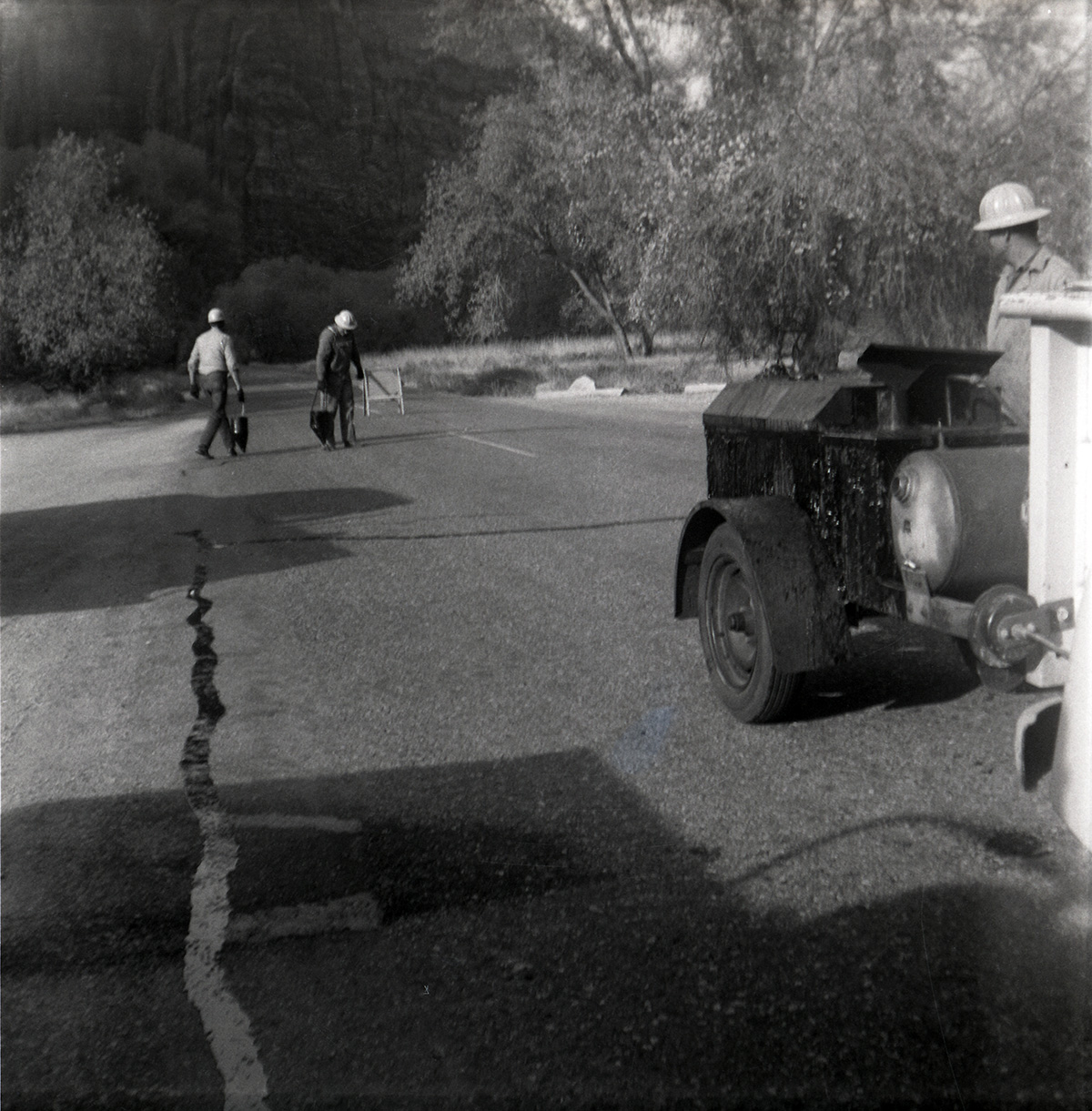 Men filling cracks in the road along the scenic canyon drive near the Grotto.