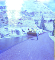 Men performing road construction with Zion landscape in background.