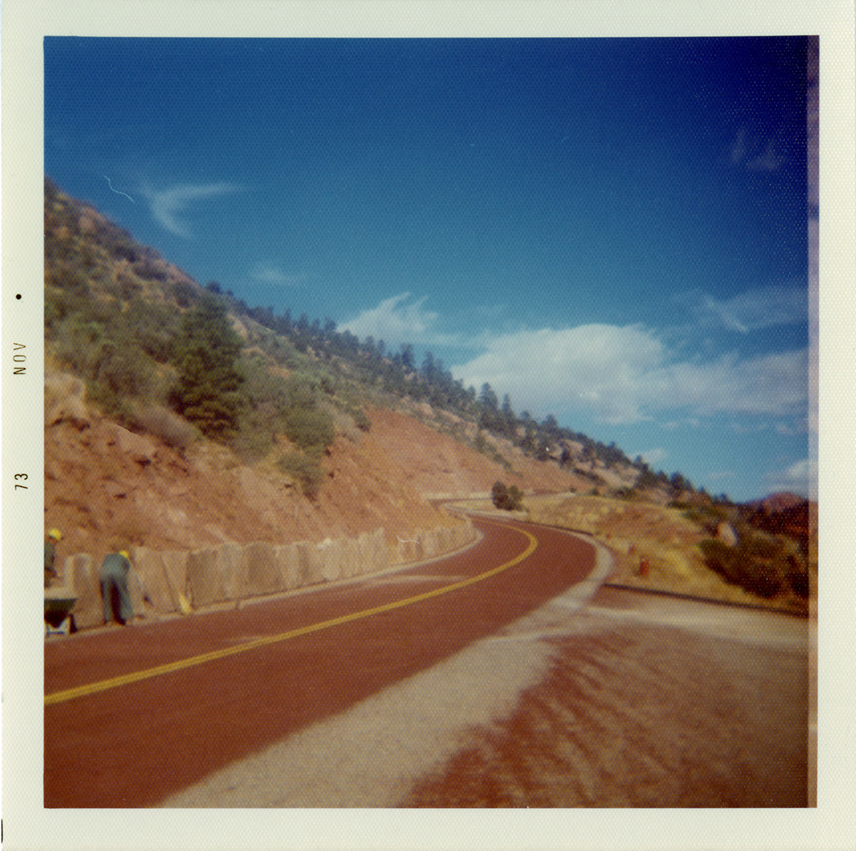 Men working on slide control wall along Kolob Canyon Road with landscape in the background.