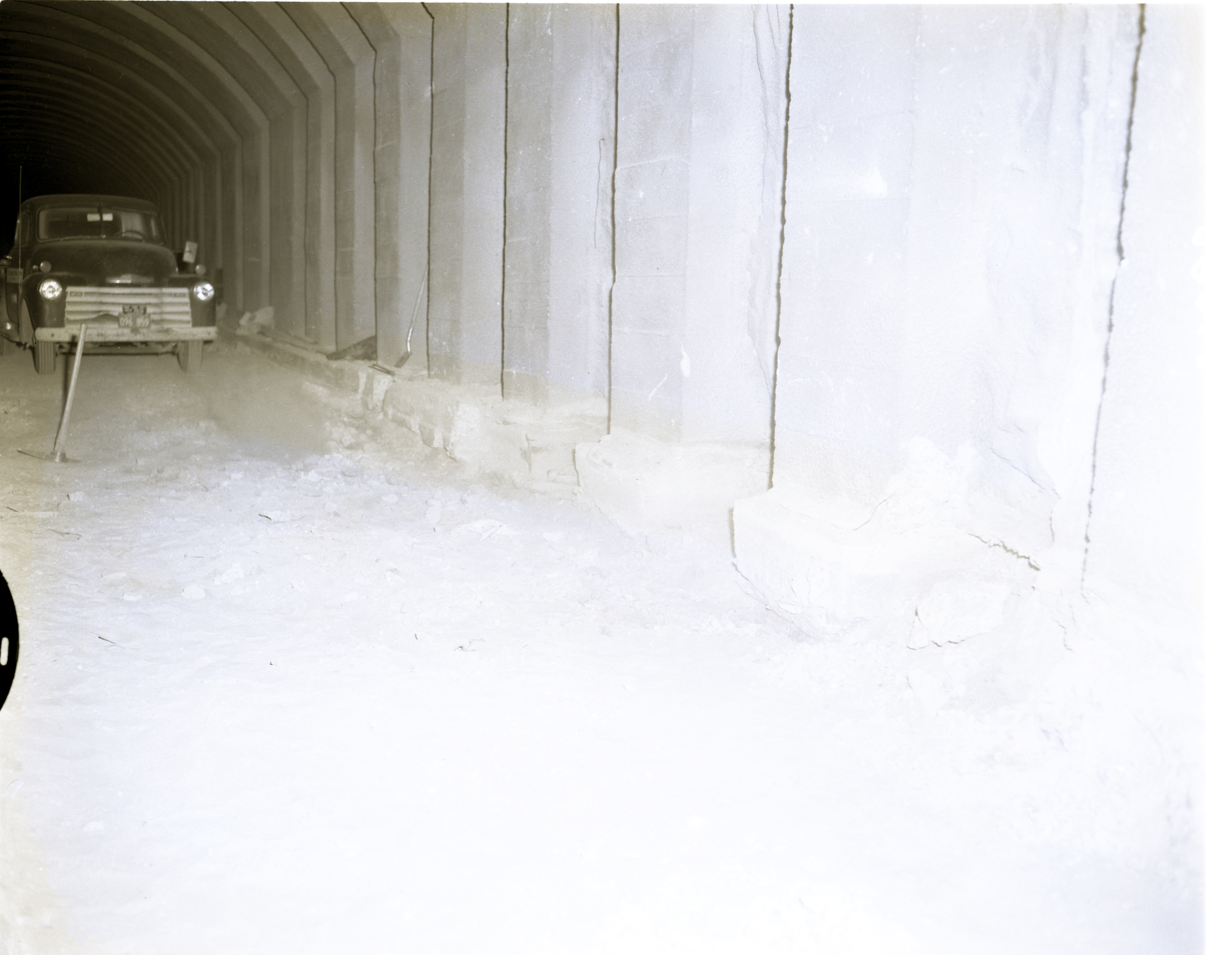 Shattered condition of tunnel wall, illustrating need for repair and danger of work of removing debris from footings.