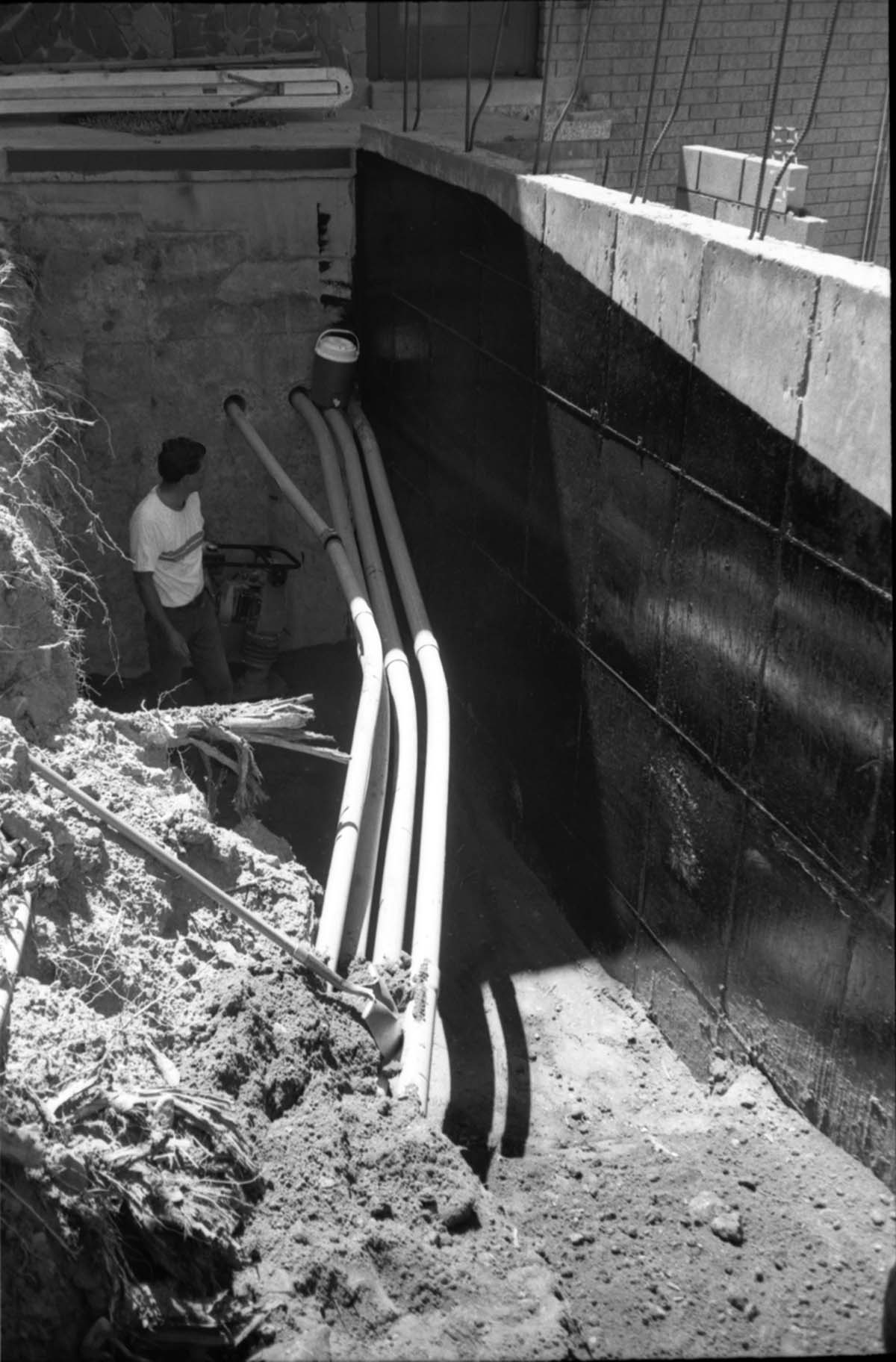 Man working on the piping during construction of headquarters addition.