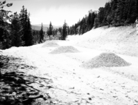 Rock aggregate piles on rim road, prior to graveling road.