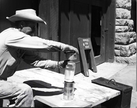 BW Photos of maintenance equipment. Man holding can over bottle. Sign in background reads: Horses for Rent.
