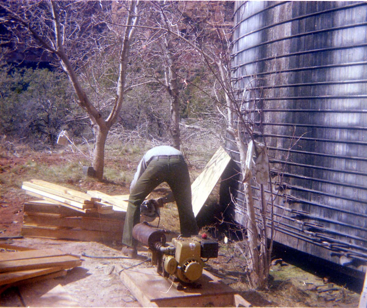 Man sawing lumber for scaffolding used in reroofing project.