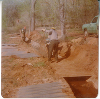Men digging and working to uncover the irrigation ditch in South Campground.
