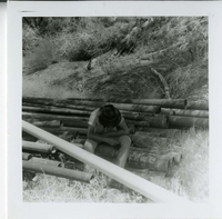 Navajo worker sitting during the utility project at Watchman housing.