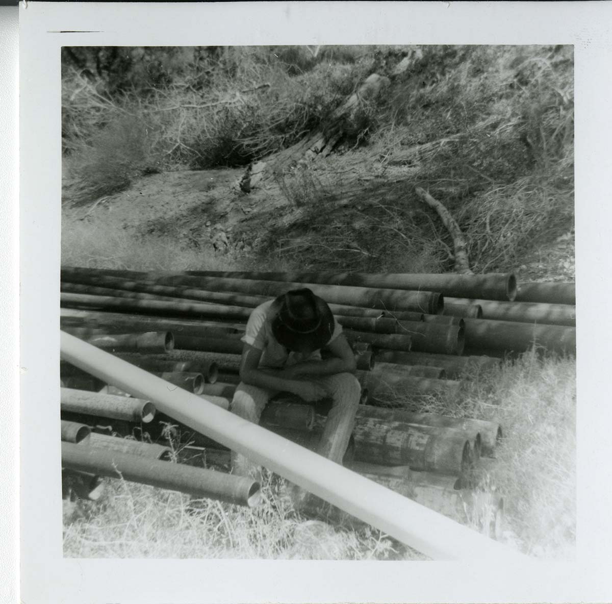 Navajo worker sitting during the utility project at Watchman housing.