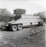 Excavator dumping pile of dirt into back of construction truck during road grading to Chamberlain Ranch and the Narrows.