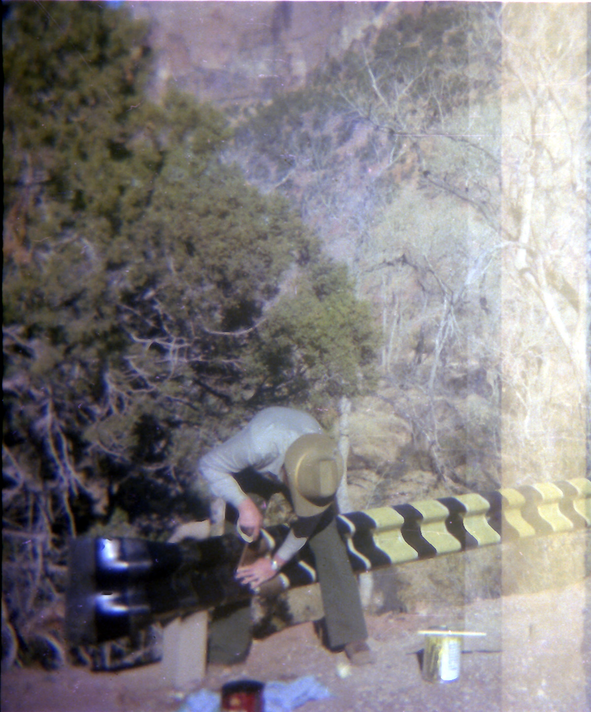Man taping road side barrier.