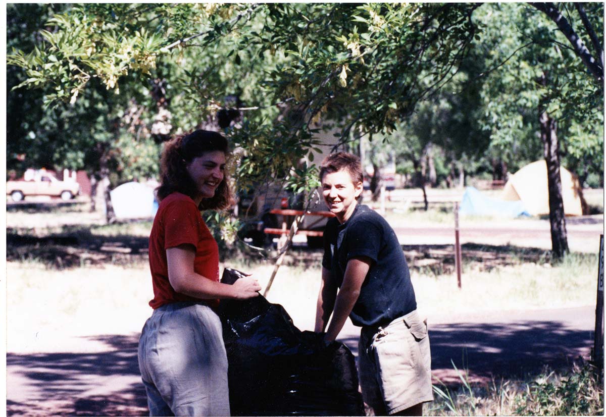 NPS employee picking up litter in campground area.