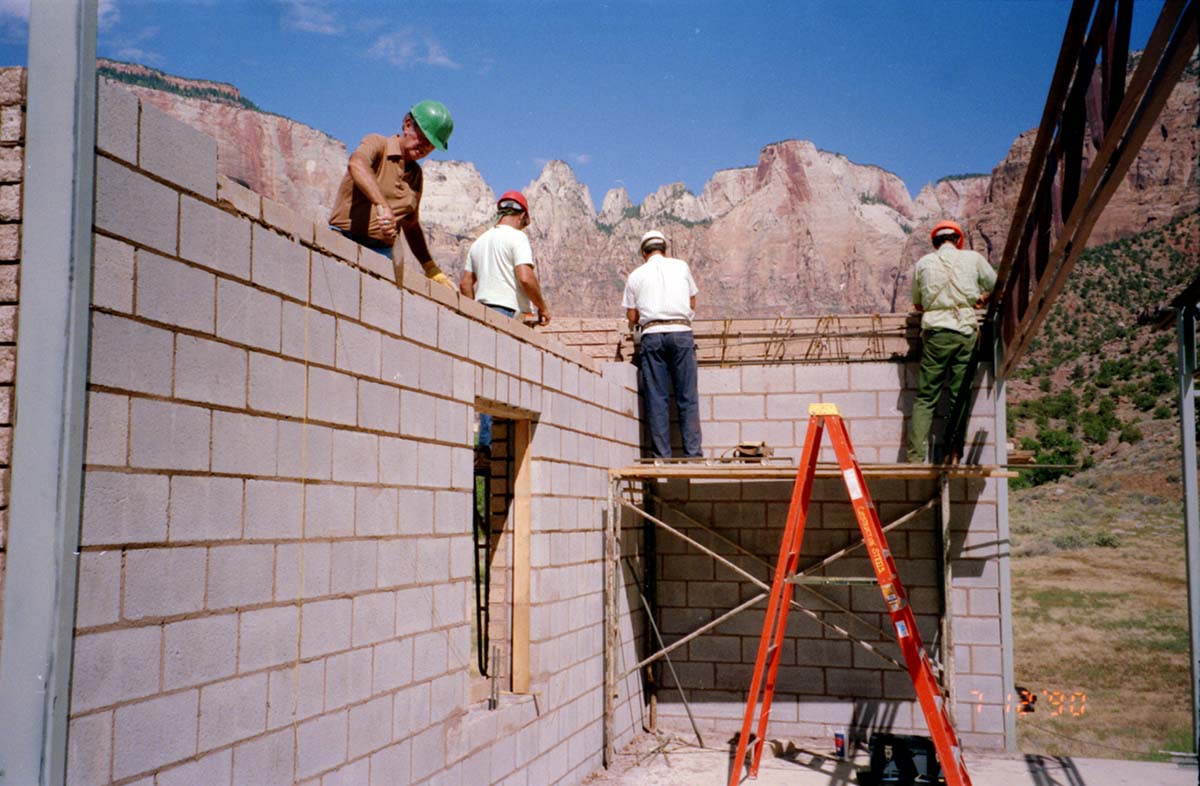 Men laying bricks during the construction of headquarters addition.