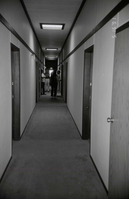 Four men in hallway of barracks. [Image possibly for comparative housing study]