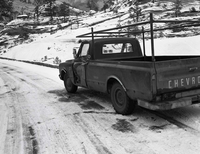 Snowplow accident, county line curve along East Entrance road showing vehicle that slid into snow plow and skid marks.