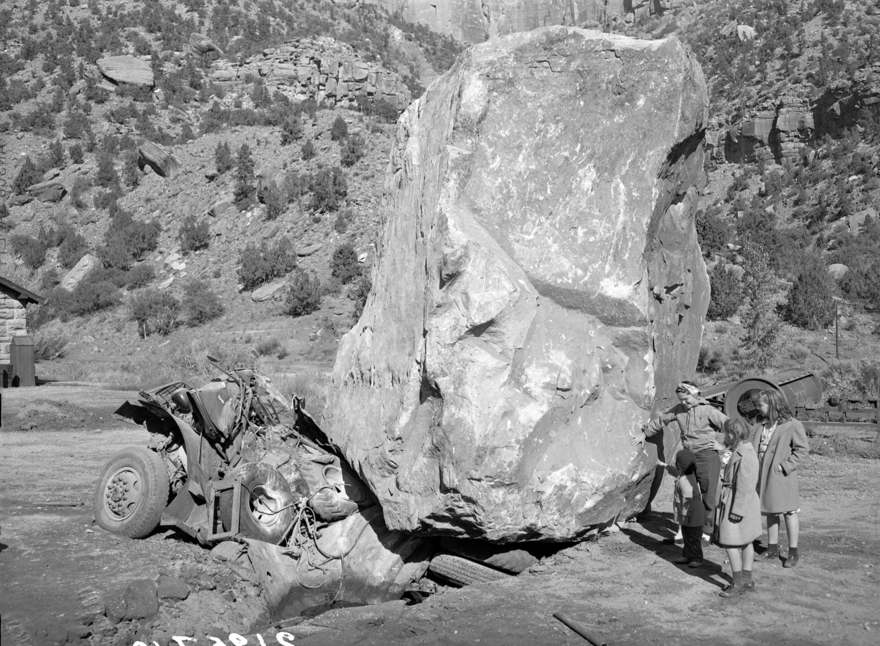 Rock slide damages of November 23, 1947, Oak Creek utility yard (maintenance area) an 880-ton boulder comes to rest on auto car.