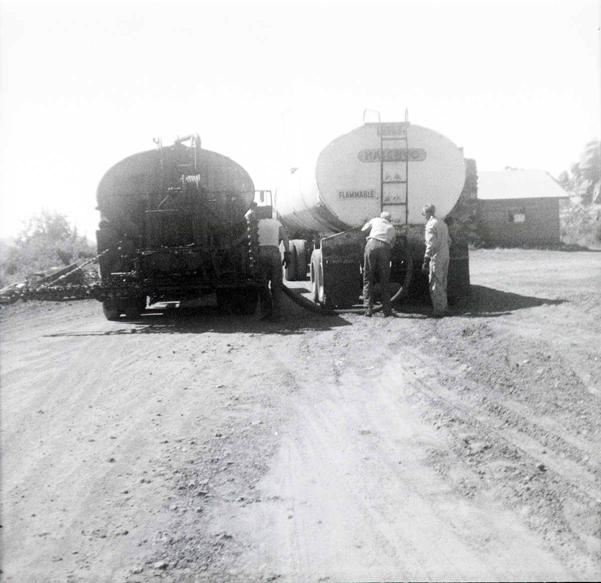 Men working on construction vehicles during chipsealing of Kolob Canyon Road.