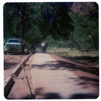 Men working on parking area and sidewalk near the new Grotto footbridge.