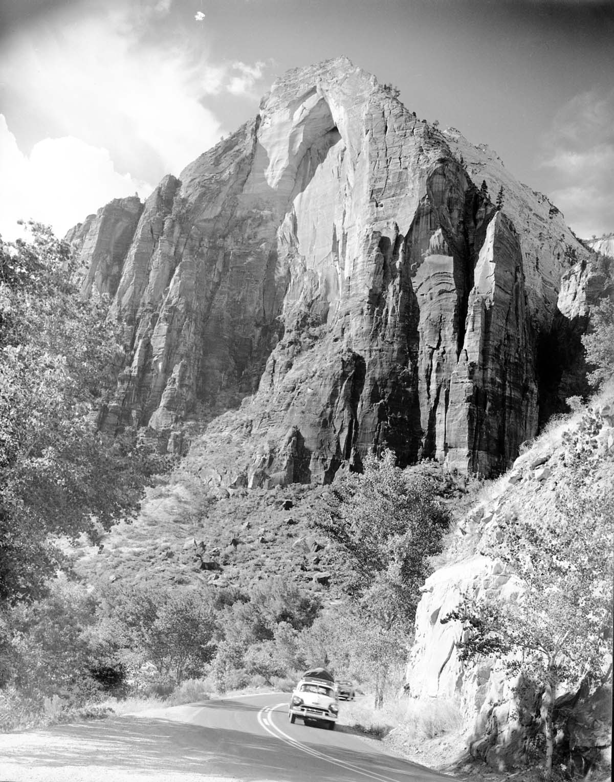 Red Arch Mountain. Cars on Zion-Mt. Carmel Highway in foreground.