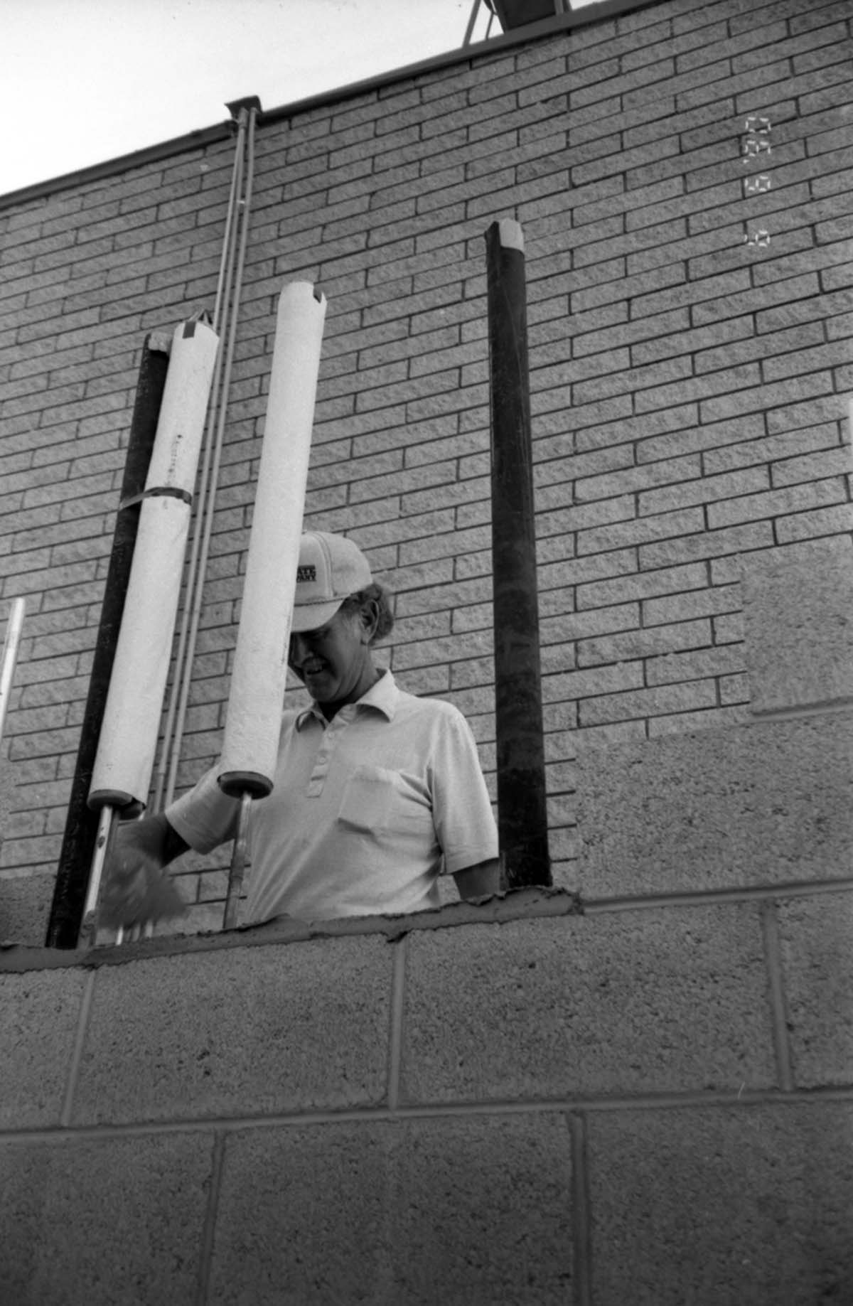 Man worker laying bricks during the construction of headquarters addition.