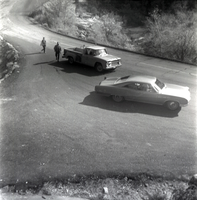 Vehicles on road with people walking during east side road repair and turn out construction.