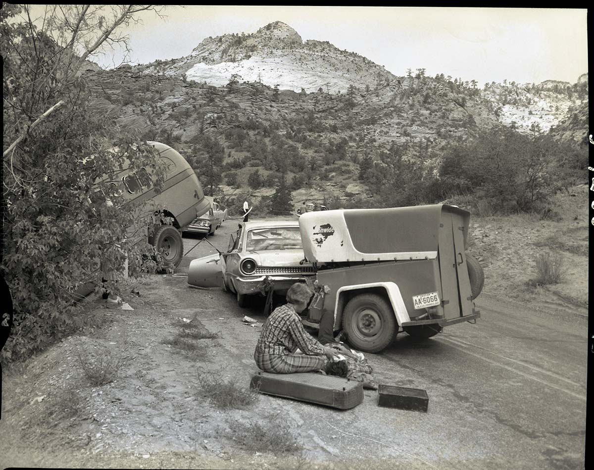 Collision between private car (Ford) towing a U-Haul trailer and (Utah Parks Company) bus on the Zion-Mt. Carmel Highway just east of the small tunnel.