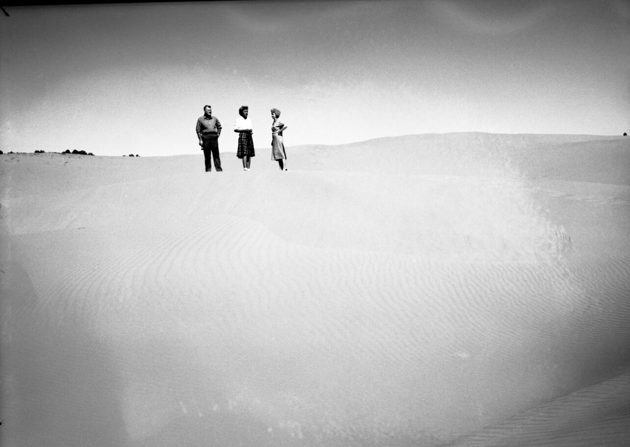Man and two women standing on the sand at Coral Pink Sand Dunes near Kanab, Utah.