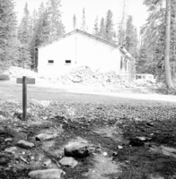 Side view of the utility and maintenance building under construction, with man working on scaffold.