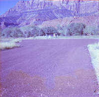 Road during chipsealing with building in the background.
