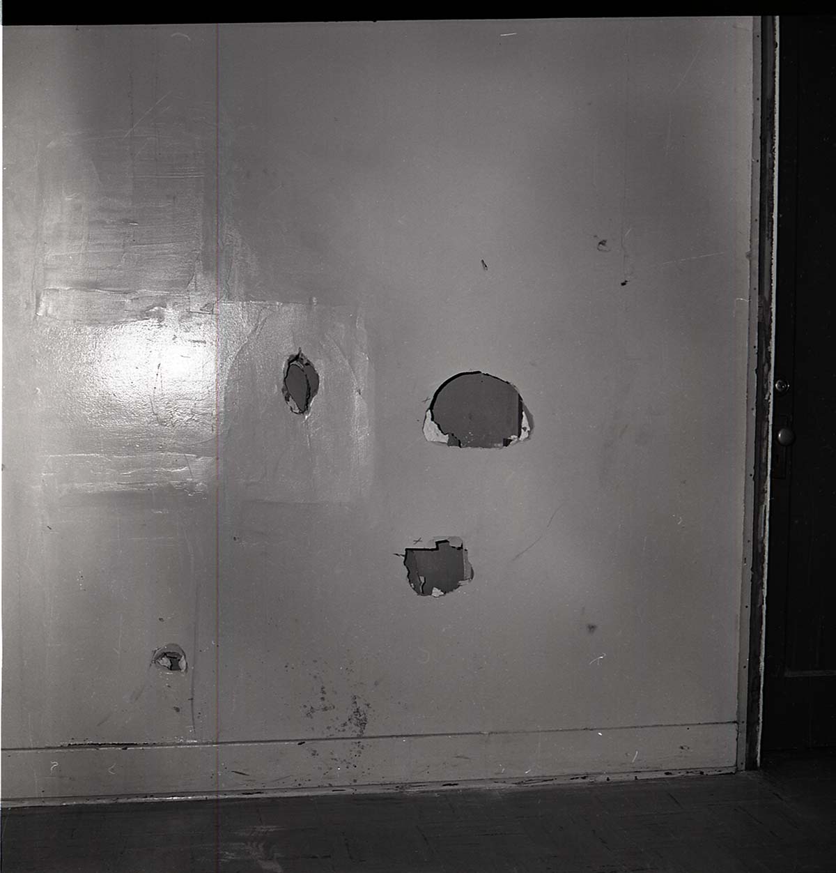 Damage to men's dorm at Zion Lodge. Holes in the door.