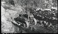 East Rim Trail construction, view of man on a bulldozer moving earth along the route of the trail.
