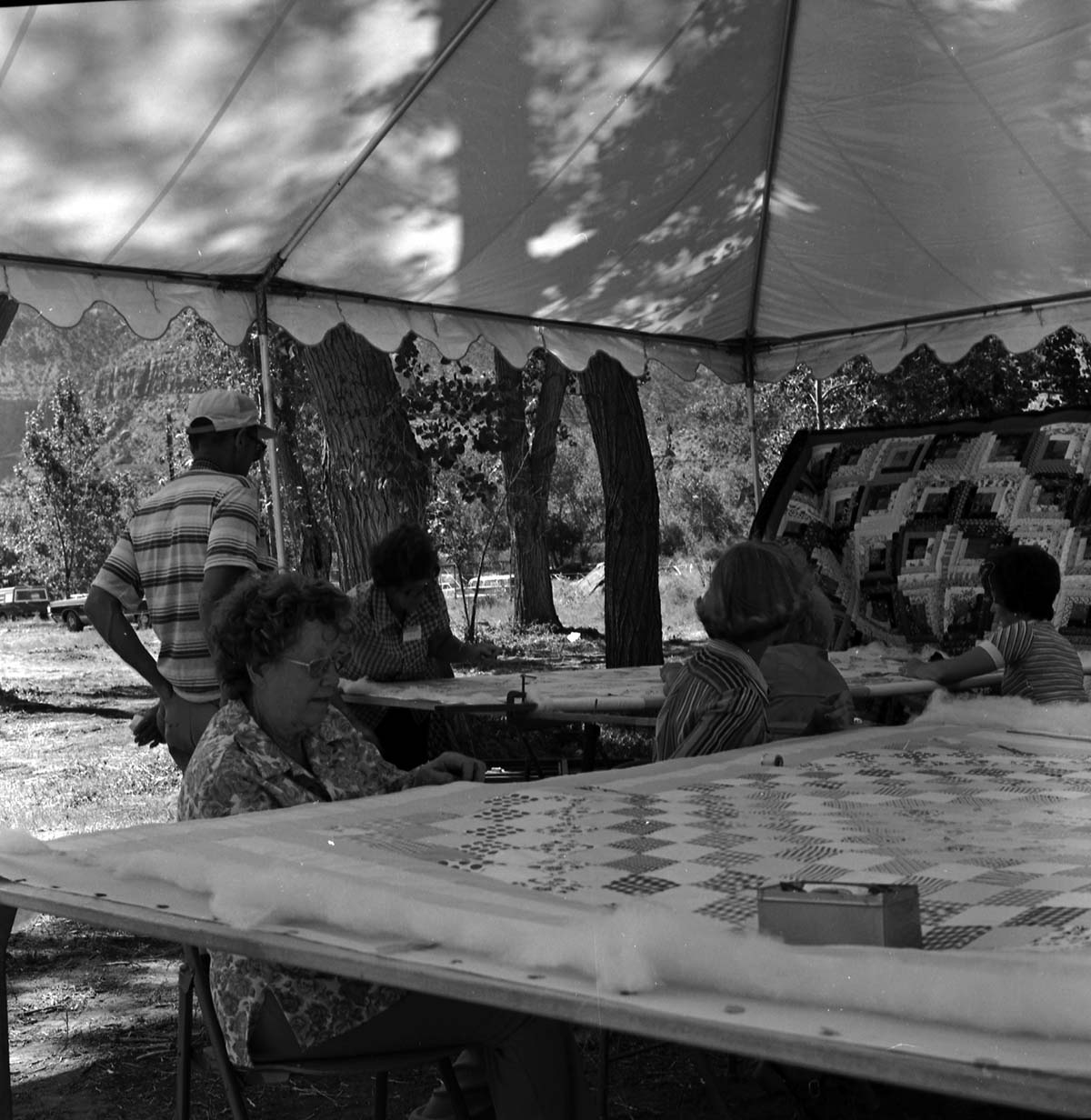 Vilo DeMille and four women demonstrating quilting for visitor at the first annual Folklife Festival, Zion National Park Nature Center, September 1977.