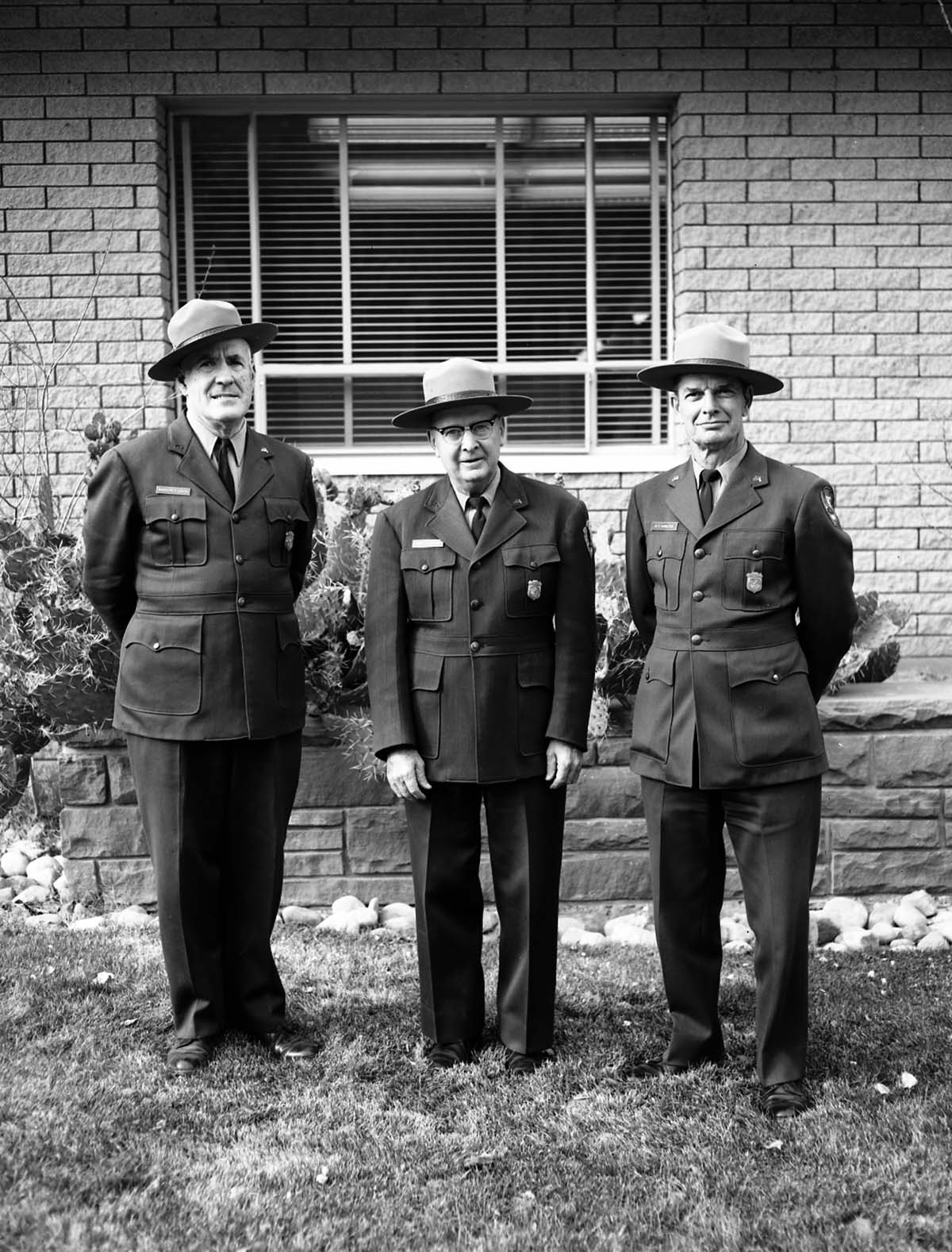 Rudy Lueck (left) and Carl E. Jepson (center) at time of their retirement standing with Superintendent Warren F. Hamilton (right). Mission 66 Visitor Center and Museum and headquarters.