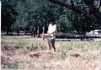 NPS employee picking up litter in campground area.