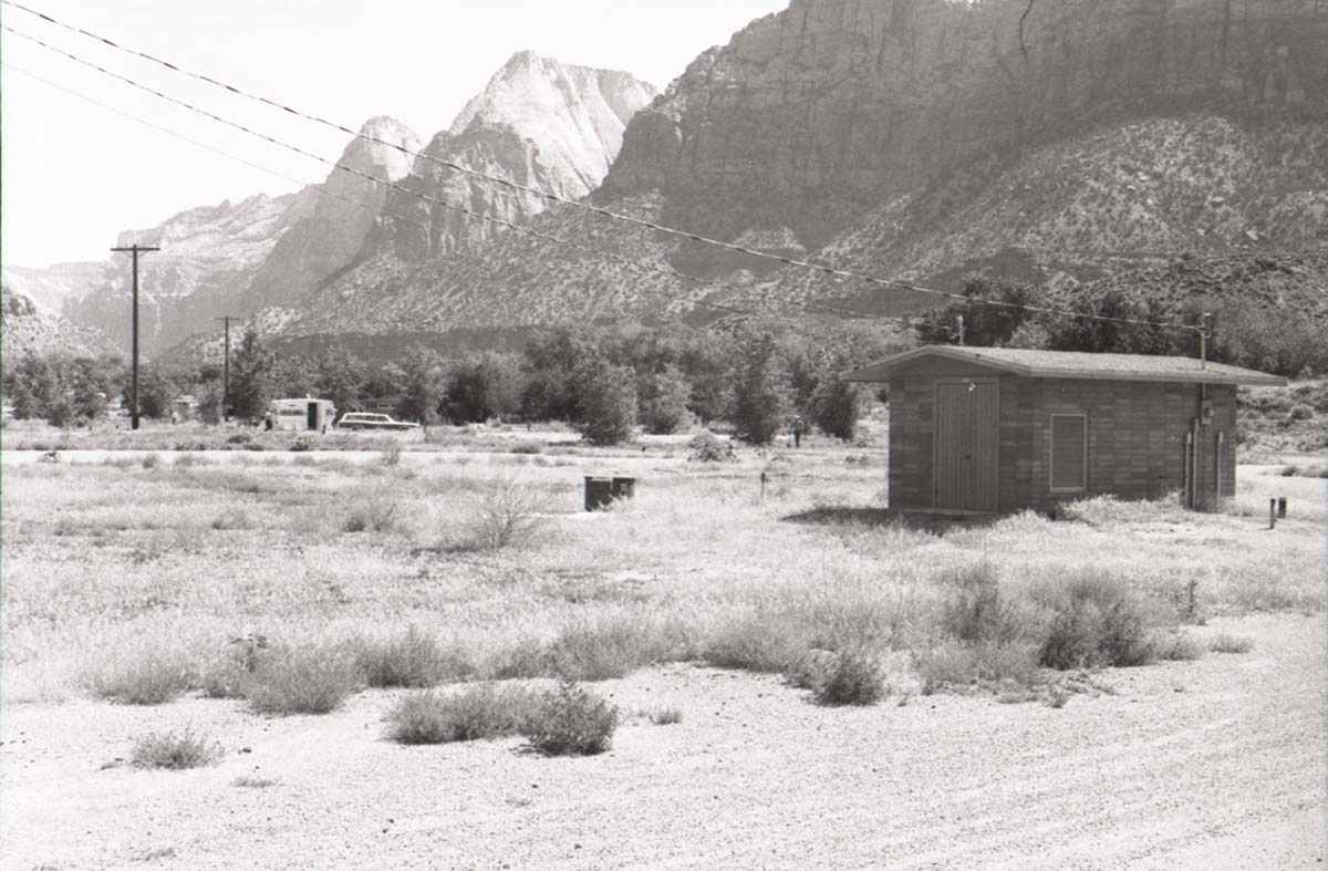 Watchman Campground building with Zion mountains in background.