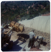 Rocks being place on tarp and men working on repairing road in Kolob Canyon.