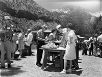 Superintendent Frank R. Oberhansley being served at barbecue following the dedication program at the Mission 66 Visitor Center and Museum. Utah Parks Company (Union Pacific Railroad) staff serving park employees and visitors near Oak Creek residential area. Over 600 people attended ceremony.
