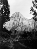Bridge Mountain from Oak Creek Canyon. Two-track road and building in foreground.