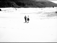 Man and woman standing on the sand at Coral Pink Sand Dunes near Kanab, Utah.