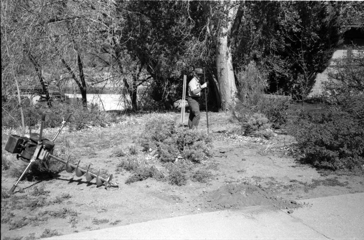 Man placing poles in ground during construction of headquarters addition.