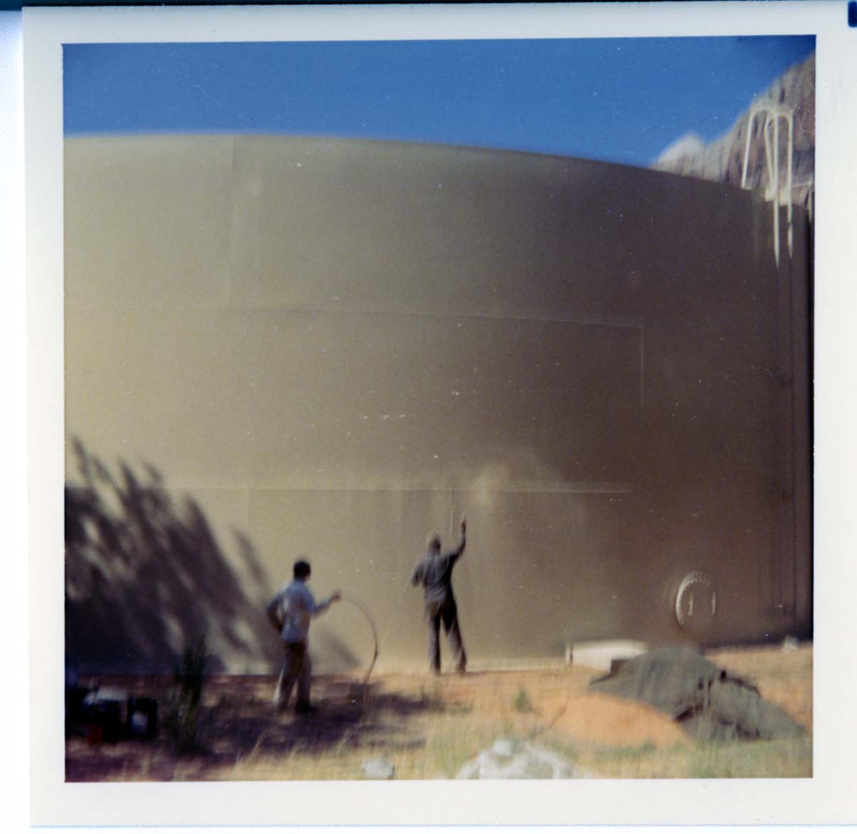Workers repainting the exterior of the million gallon water tank at Birch Creek.