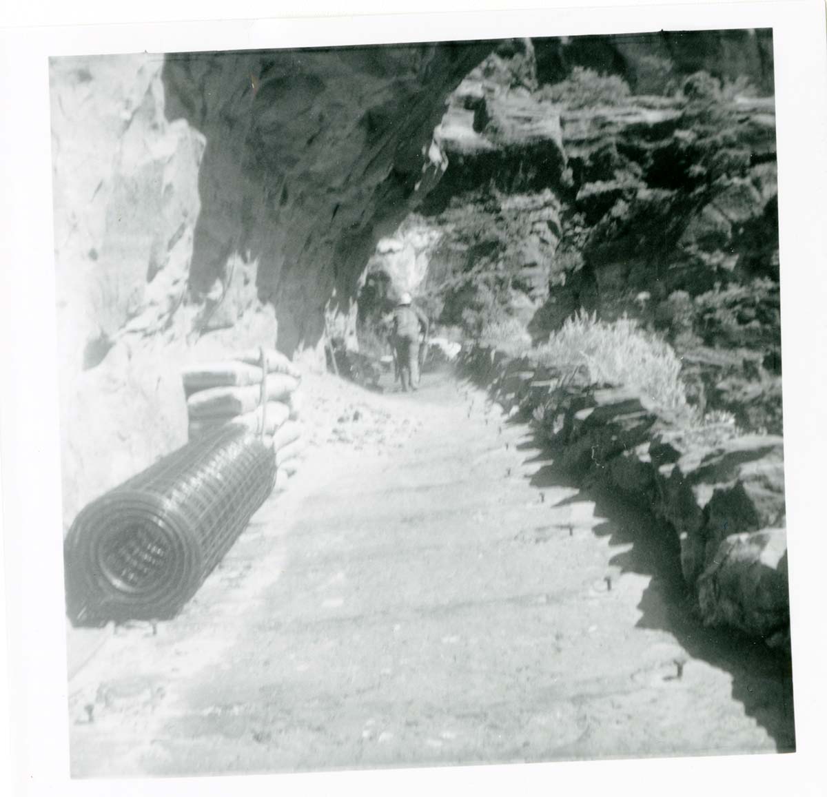 Workers operating construction equipment during the West Rim trail half tunnel maintenance/stabilization.