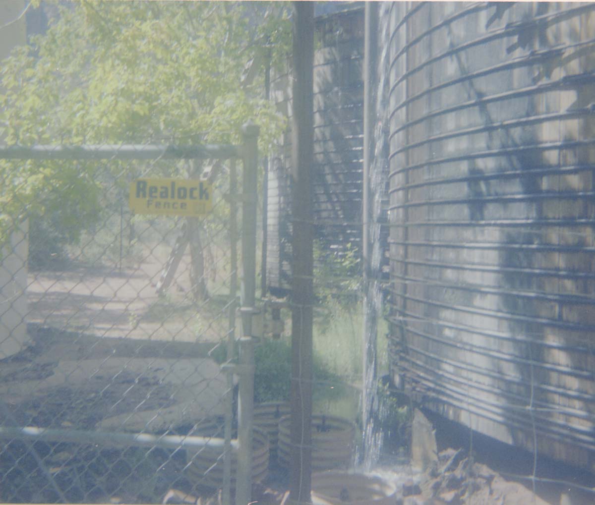 Fence and gate surrounding water tanks involved in reroofing project.
