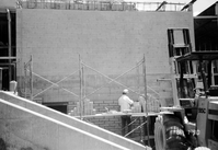 Worker adding bricks to brick wall during construction of headquarters addition.