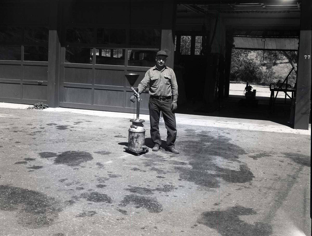 BW Photos of man standing next to maintenance equipment.