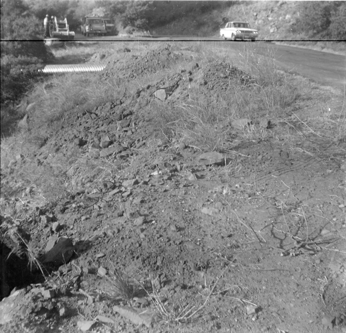 Car driving along the scenic canyon drive with tractor working on construction.