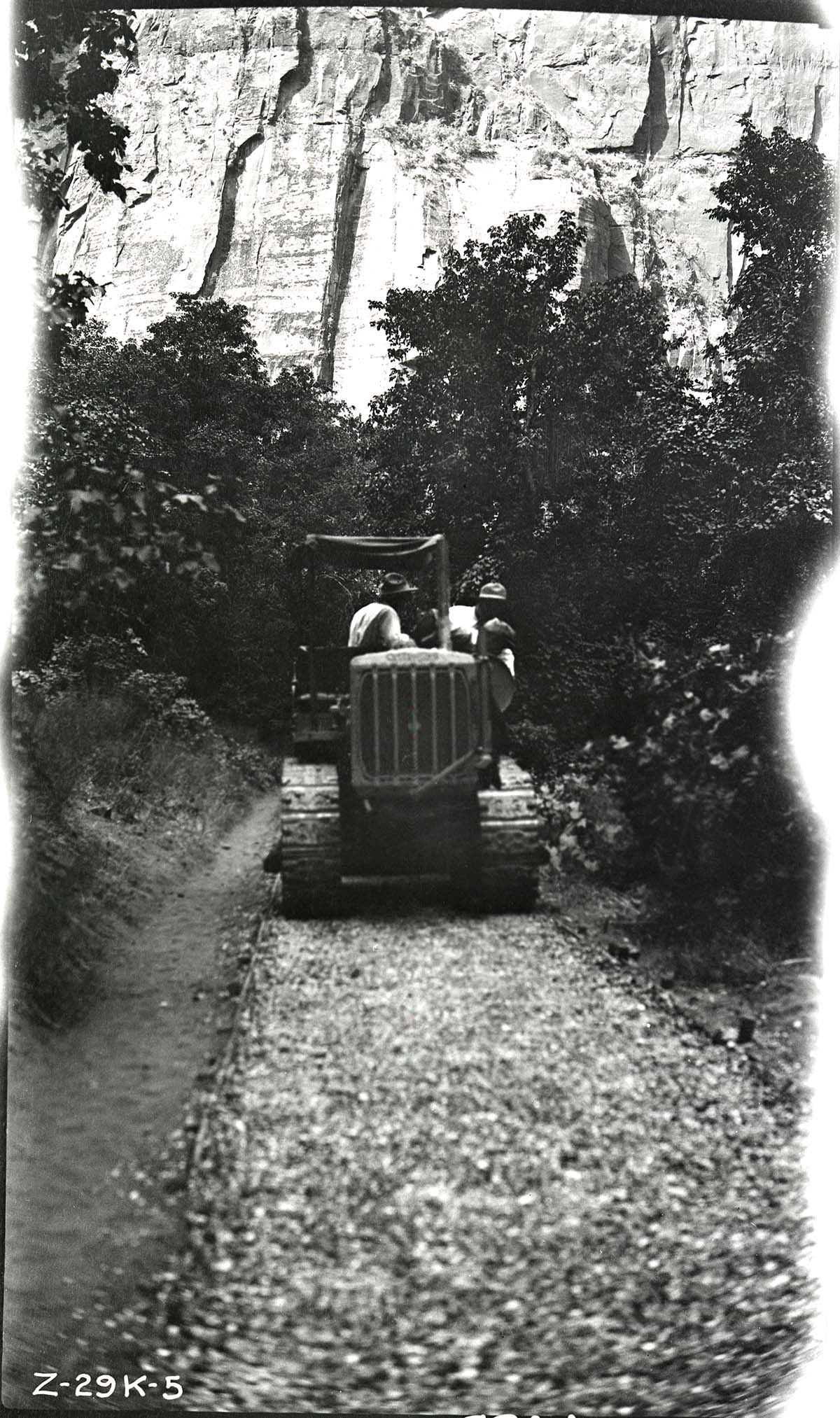 Narrows Trail construction with a view of workers on a caterpillar tractor rolling the base.