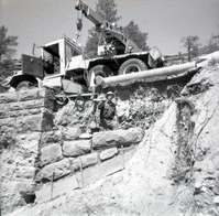 Crane placing rock bricks during the repair of retaining wall along East Rim road.