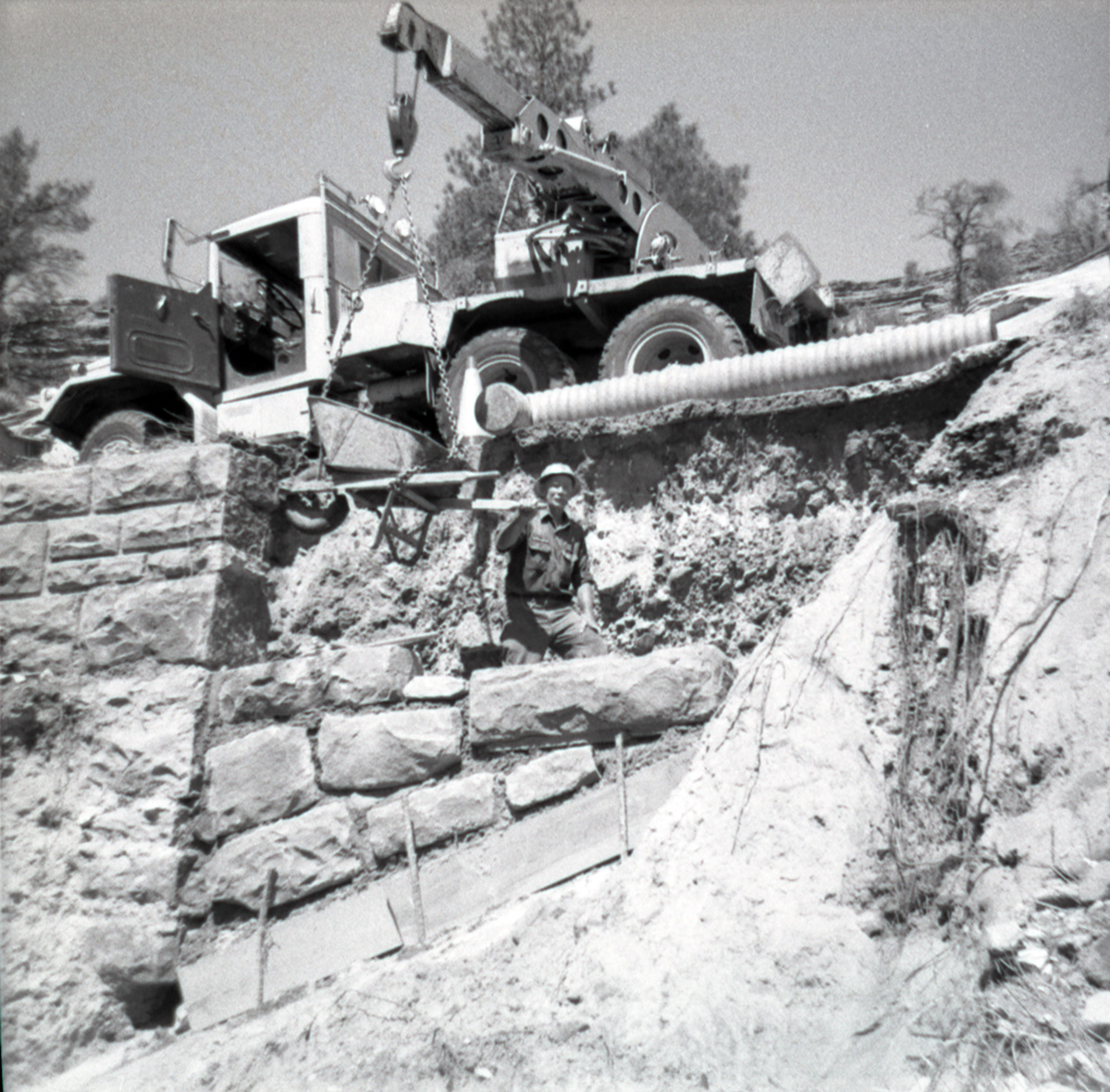 Crane placing rock bricks during the repair of retaining wall along East Rim road.