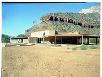 Exterior of old Mission 66 Visitor Center and Museum, with dirt lot surrounding building.