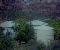 Three water tanks with new paint applied during reroofing project.